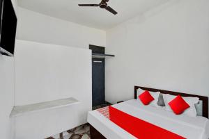 MurādnagarOYO Flagship Amazing Inn的一间卧室配有红色枕头的床