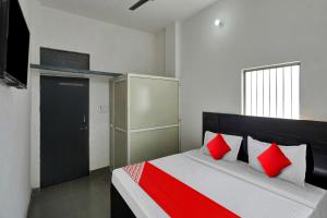 MurādnagarOYO Flagship Amazing Inn的一间卧室配有红色和白色枕头的床