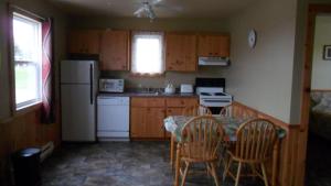 卡文迪西Mayfield Country Cottages的厨房配有桌椅和冰箱。