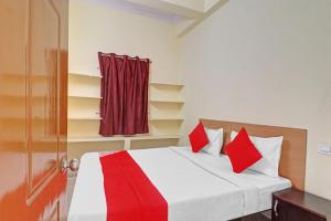 Haidar Sāhibgūda80983G RBS Square Langer Houz的一间卧室配有一张带红色枕头的床和一扇门