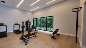 大坎普Loft Amplo e Aconchegante c/ Quarto Privativo的健身房设有健身器材和大窗户
