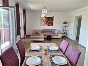 塞科夫列Val&Sol Apartments的一间带桌子和紫色椅子的用餐室