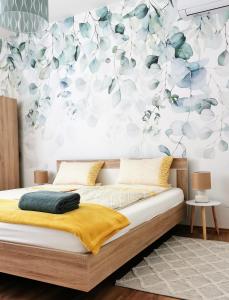 欧尔菲Life Apartman Orfű的一间卧室配有一张带花卉墙壁的床