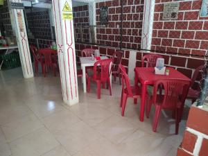 San CiprianoCasa hospedaje mayesty的一间设有红色桌椅的房间和砖墙