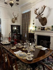 WaysideThe Belmont 1857的墙上的用餐室配有桌子和鹿头
