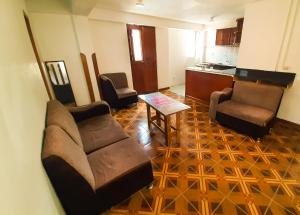 库斯科Peru Hostel Inn Plaza的客厅配有沙发、椅子和桌子