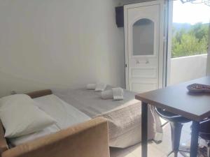 阿基欧斯尼古拉斯Irini Apartment的一间卧室配有一张床、一张桌子和一个窗户。