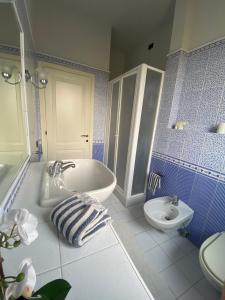 芬奇La Casina di Nonno Enzo的蓝色和白色的浴室设有浴缸和水槽