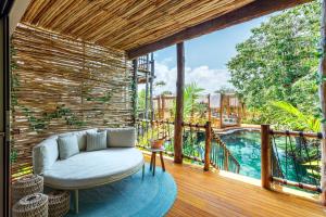 图卢姆Hotel Shibari - Restaurant & Cenote Club的客厅设有沙发,位于带游泳池的甲板上