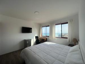 蓬塔赫尔莫萨Casablanca del Mar的卧室设有白色的床和大窗户