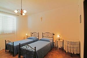 佩斯卡拉Agriturismo Il Tratturo的一间卧室设有两张床、一张桌子和一个窗口