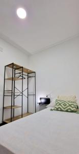 库列拉Loft el Baix - Cullera的卧室配有白色的床和架子