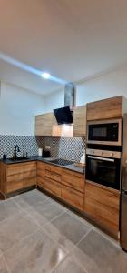 库列拉Loft el Baix - Cullera的厨房配有木制橱柜和炉灶烤箱。