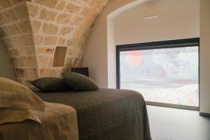 莫诺波利Suite Polignani by STHEY的一间卧室设有一张床和一个大窗户