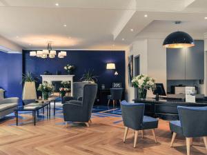 克劳德巴黎圣克卢竞技场美居酒店的沙龙设有蓝色的墙壁和钢琴