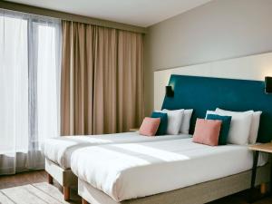 格拉斯哥Aparthotel Adagio Glasgow Central的一间卧室配有一张大床和蓝色床头板