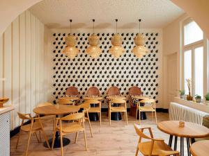 梅斯Mercure Grand Hôtel Metz Centre Cathédrale的餐厅设有木桌、椅子和墙壁