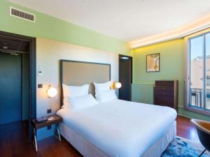 安锡Le Splendid Hotel Lac D'Annecy - Handwritten Collection的卧室设有一张白色大床和一扇窗户。