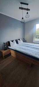 文戈热沃Apartament "Słoneczny" Kraszewskiego的卧室配有一张带白色床单的大床和窗户。