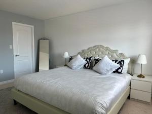 米西索加Cozy 5 Bedroom House Mississauga的卧室配有白色的床和黑白色枕头
