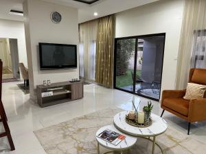卢萨卡Kaya Apartments的客厅配有电视、沙发和桌子