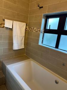 卢萨卡Kaya Apartments的带浴缸的浴室和窗户