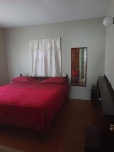 Gwa KayCampbell's living accommodations.的一间卧室设有红色的床和窗户。