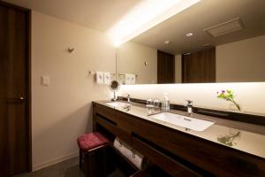 仙台Hotel GrandBach Sendai的一间带水槽和大镜子的浴室