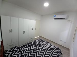 波萨达斯Casa Costa Sur的卧室配有白色橱柜和黑白地毯。