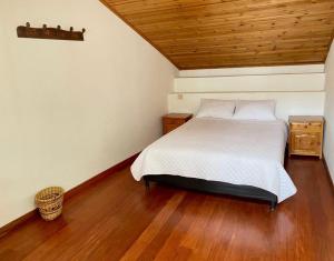 SusaHospedaje Casa Lola的一间卧室设有一张床和木制天花板