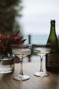 阿波罗湾Point of View Villas的桌子上放着三杯酒,还放着一瓶葡萄酒