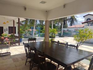 圣若泽-迪里巴马尔Casa de Praia Panaquatira - São J. Ribamar的一间带木桌和椅子的用餐室