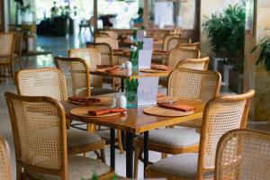 库塔Crystalkuta Hotel - Bali的餐馆里一排木桌和椅子