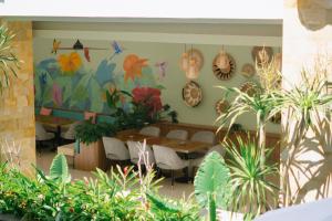 库塔Crystalkuta Hotel - Bali的一间餐厅,房间里摆放着桌子和植物