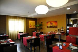 卡索里亚芙萝娅酒店的餐厅配有桌椅和红色桌布