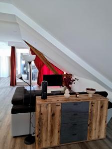 布雷根茨Wohnen über den Dächern von Bregenz的客厅配有沙发和书桌,位于楼梯下