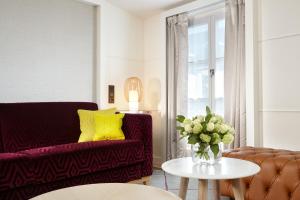 巴黎里什庞斯歌剧院酒店的客厅配有沙发和带花瓶的桌子