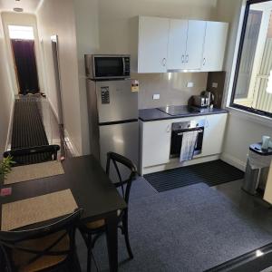 布罗肯希尔City Villa 41 Blende st Broken Hill NSW 2880的厨房配有冰箱、桌子和微波炉