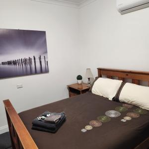 布罗肯希尔City Villa 41 Blende st Broken Hill NSW 2880的一间卧室,配有一张带硬币桌子的床