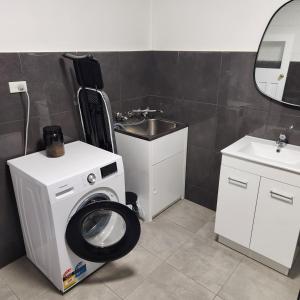 布罗肯希尔City Villa 41 Blende st Broken Hill NSW 2880的一间带洗衣机和水槽的浴室