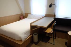东京ホテルレジデンス大橋会館 by Re-rent Residence的客房设有两张床、一张桌子和一把椅子。