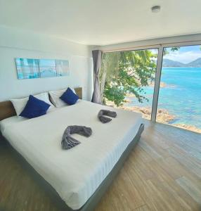芭东海滩patong sunset villa Phuket的一间卧室配有一张床,并备有2个拖鞋