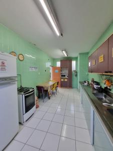 萨尔瓦多Nomads Hostel Multicultural & Coworking的厨房设有绿色的墙壁和白色的瓷砖地板。