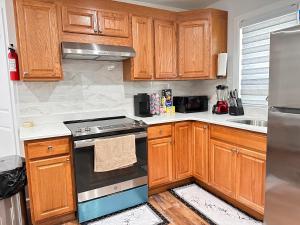 威克斯巴勒Serene Escape Leave Worries Behind的厨房配有木制橱柜和炉灶烤箱。