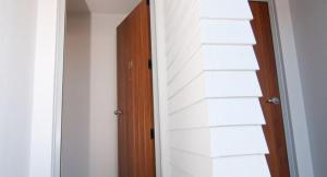 玛塔玛塔百老汇汽车旅馆米罗苑别墅的一道门通向一个白色墙壁的房间