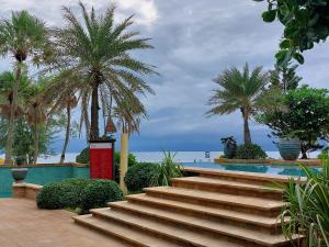 卡伦海滩Karon Sea View Beach Apartment的棕榈树泳池旁的楼梯