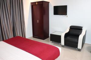 吉隆坡Hotel AL Amin的配有床、椅子和电视的房间