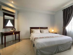 吉隆坡Hotel AL Amin的一间卧室配有一张大床和一张书桌