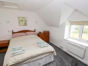 彭布罗克No 2 New Cottages的一间卧室配有一张床,上面有两条毛巾