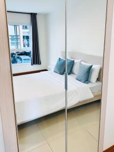 曼谷The Lodge @ Min Residence的卧室内的镜子,卧室配有床和窗户